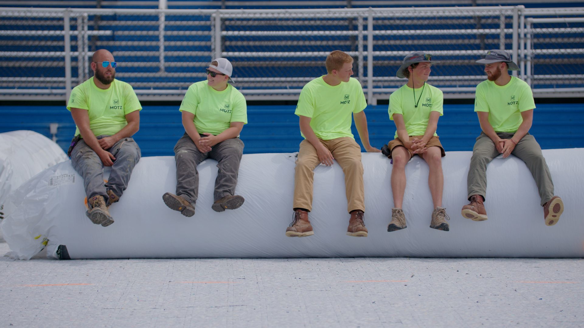 field crew sitting on turf roll